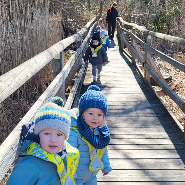 Enfants souriants en promenade sur un ponton dans la Grande Cariçaie