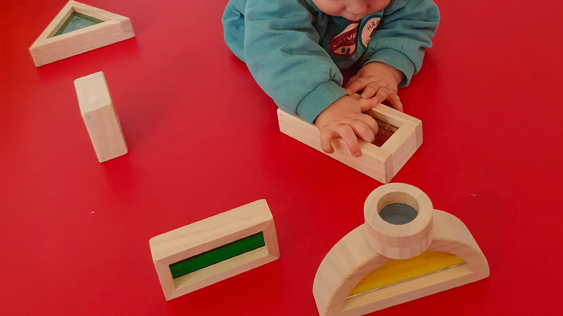 Bébé explorant les sons d’un bloc en le secouant à la crèche de l’EPFL.