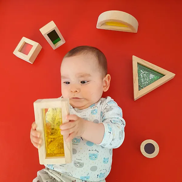 Enfant de la nursery manipulant un bloc sensoriel transparent à la crèche La Nanosphère.